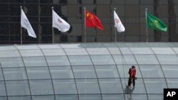 A worker descends on the rooftop of a building at the central business district in Beijing, China, July 15, 2024. China's Communist Party is starting a meeting Monday expected to lay out a strategy for self-sufficient economic growth.