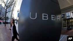 FILE- A woman leaves Uber headquarters of Uber in San Francisco, California.
