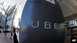 FILE- A woman leaves Uber headquarters of Uber in San Francisco, California.