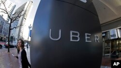 FILE- A woman leaves Uber headquarters of Uber in San Francisco, California.