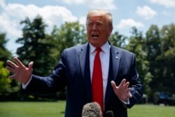 President Donald Trump talks with reporters on the South Lawn of the White House before departing to Japan for the G-20 summit, June 26, 2019.