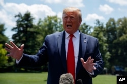 President Donald Trump talks with reporters on the South Lawn of the White House before departing to Japan for the G-20 summit, June 26, 2019.