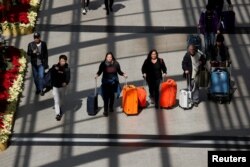 FILE - Passengers leave Hong Kong International Airport in Hong Kong, Jan. 11, 2018.