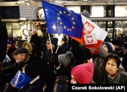 Pengunjuk rasa membawa bendera Uni Eropa pada protes anti-pemerintah di Warsawa, Polandia. Beberapa orang Polandia khawatir konflik yang berlarut-larut dengan UE mengenai anggaran dapat membuat mereka meninggalkan blok tersebut. (Foto: AP/Czarek Sokolowsk