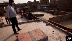 Relatives stand on the terrace of a house where a 15-year-old girl was set on fire after being raped at Tigri village, near Noida, a suburb of New Delhi, India. Police on Wednesday said that girl who was raped and set on fire this week has died in the New Delhi hospital where she was being treated for severe burns.