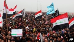 FILE - Sunni protesters chant slogans against the Iraq's Shiite-led government as they wave national flags during a 2013 demonstration in Fallujah.