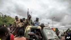 FILE - People cheer in celebration as security forces drive through the streets of the capital Bamako, Mali, Aug. 19, 2020. The military leaders of Mali, Burkina Faso and Niger signed a mutual defense pact over the weekend.
