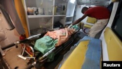 A medic places the body of a woman in an ambulance after she was killed by clashes between government forces and Houthi fighters near Hodeida, Yemen June 15, 2018.