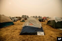 A sign hangs beside a tent at a makeshift shelter for evacuees of the Camp Fire in Chico, Calif., Nov. 14, 2018.