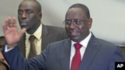 Senegalese opposition presidential candidate Macky Sall (R) celebrates at a news conference in Dakar, Senegal, March 25, 2012.