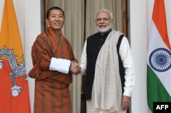 Perdana Menteri Bhutan Lotay Tshering bersama Perdana Menteri India (kanan) berjabat tangan sebelum pertemuan di New Delhi, 28 Desember 2018.
