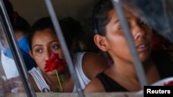 FILE - A girl looks out the window of a school in Los Limones, Guatemala, April 25, 2014. 