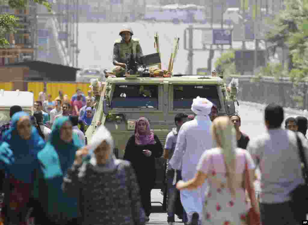 Một binh sĩ đứng trên xe bọc thép trong tư thế sẵn sàng ứng phó ở gần Quảng trường Nahda, nơi những người ủng hộ Tổng thống bị lật đổ Mohamed Morsi dựng trại, Cairo, 12 tháng 8, 2013.