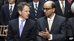 US Treasury Secretary Timothy Geithner speak with Singapore FM Tharman Shanmugaratnam, right, during the official group photo at International Monetary Fund (IMF) and World Bank Annual Meetings at IMF headquarters in Washington, September 24, 2011.