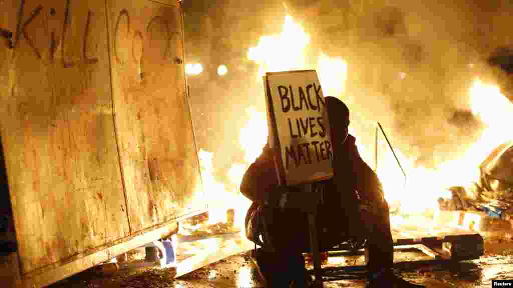 Un manifestant se trouve en face d&#39;un incendie de la rue lors d&#39;une manifestation après la grande décision du jury dans la fusillade Ferguson, Missouri de Michael Brown, à Oakland, en Californie, 25 Novembre 2014.