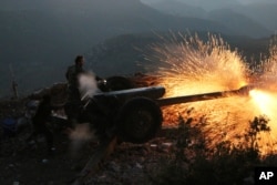 FILE - Syrian army personnel backed by Russian airstrikes fire cannon in Latakia province, near the border with Turkey, Oct. 10, 2015.
