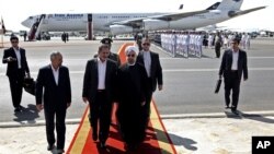 Iranian President Hassan Rouhani, center, walks with and Vice President Eshagh Jahangiri, center left, at Mehrabad airport in Tehran, Iran, Sept. 28, 2013. 