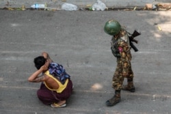 FILE - A soldier detains a man during a protest against the military coup, in Mandalay, Myanmar, March 3, 2021.