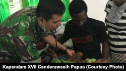 Tim dokter TNI yang dikirim ke Asmat memeriksa kondisi anak-anak yang terkena campak dan menderita kekurangan gizi.