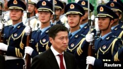 FILE - Sukhbaatar Batbold, then prime minister of Mongolia, inspects an honor guard during an official welcoming ceremony in the Great Hall of the People in Beijing, June 16, 2011.