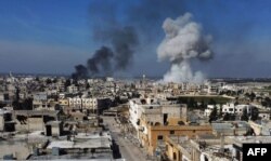 FILE - Smoke billows over the town of Saraqeb in the eastern part of the Idlib province in northwestern Syria, following bombardment by Syrian government forces, Feb. 27, 2020.