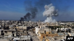Smoke billows over the town of Saraqeb in the eastern part of the Idlib province in northwestern Syria, following bombardment by Syrian government forces, Feb. 27, 2020. 
