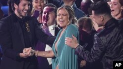 Karol G es felicitada por colegas antes de subir al escenario para recibir el Latin Grammy al Mejor Artista Nuevo.