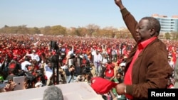 Leader of Zimbabwe's opposition party Movement For Democratic Change (MDC) Morgan Tsvangirai greets supporters at a rally in Harare, July 29, 2013. 