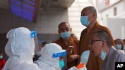 Monks get tested for the coronavirus in a district in Guangzhou in southern China's Guangdong province on May 30, 2021. 