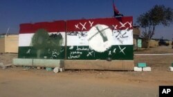 Barriers with defaced Kurdish flags are seen outside an evacuated checkpoint in the village of Bashir, south of Kirkuk, Iraq, Oct. 13, 2017.