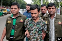 FILE - Members of Bangladesh police escort a man whom they have identified as Shariful, a member of a banned Islamic group, as they walk him in front of the media in Dhaka, Bangladesh, May 15, 2016.