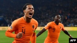 Bek timnas Belanda, Virgil van Dijk (kiri) merayakan hasil imbang 2-2 dalam laga UEFA Nations League antara Jerman vs Belanda di Gelsenkirchen, 19 November 2018.