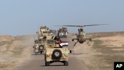 FILE - A convoy of Iraqi forces is seen moving through the Samarra desert, on the border between Anbar and Salahuddin provinces, Iraq, March 9, 2016.