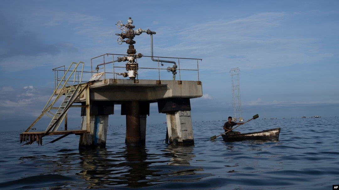 Una embarcación navega cerca de un pozo petrolero del Lago de Maracaibo, en Venezuela, en octubre de 2022. Este martes, se supo que una refinería india presentó una nueva solicitud a Estados Unidos para trabajar en Venezuela.