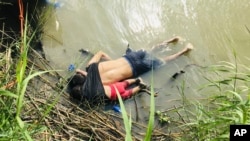 The bodies of Salvadoran migrant Oscar Alberto Martínez Ramírez and his nearly 2-year-old daughter Valeria lie on the bank of the Rio Grande in Matamoros, Mexico, Monday, June 24, 2019, after they drowned trying to cross the river to Brownsville, Texas. (AP Photo/Julia Le Duc)