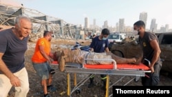 Un hombre herido que quedó debajo de un vehículo tras la explosión en el puerto de Beirut es trasladado a un hospital, en Beirut, el 4 de agosto de 2020.