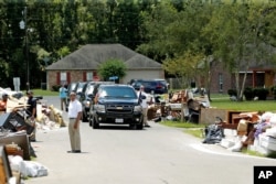 U.S. President Barack Obama's motorcade is seen nearby as he tours a flood-affected neighborhood in Zachary, Louisiana, Aug. 23, 2016.