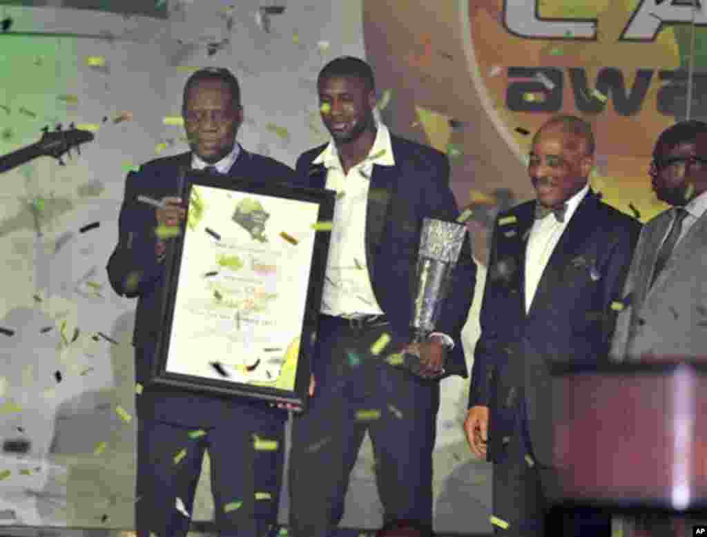 Ivory Coast midfielder Yaya Toure, second left, holds the African Player of the Year trophy he received during an award ceremony in Accra, Ghana, Thursday, Dec. 22, 2011. The Manchester City player won ahead of Mali and Barcelona midfielder Seydou Keita,