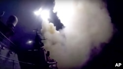 In this photo made from the footage taken from Russian Defense Ministry official web site, Wednesday, Oct. 7, 2015, a Russian navy ship launches a cruise missile in the Caspian Sea.