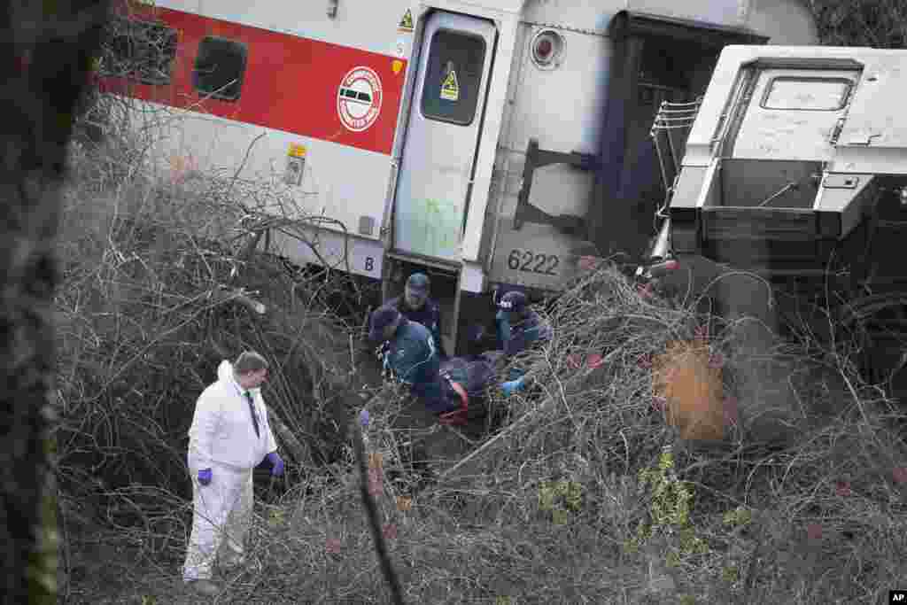 Emergency personnel remove a body from the scene of a Metro-North passenger train derailment in the Bronx borough of New York, Dec. 1, 2013. 