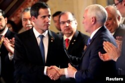 U.S. Vice President Mike Pence and Venezuelan opposition leader Juan Guaido, who many nations have recognized as the country's rightful interim ruler, shake hands during a meeting of the Lima Group in Bogota, Colombia, Feb. 25, 2019.
