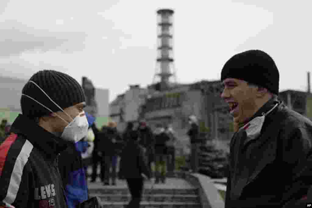 Tourists stand outside of the Chernobyl reactor. (VOA Photo/D. Markosian)