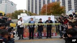 FILE - Protesters stand in front of an image of North Korea's Diamond Mountain as they stage a rally calling for the resumption of Diamond Mountain tourism in Seoul, South Korea, Oct. 28, 2019. 