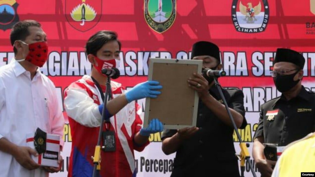 Dua pasangan kandidat Pilkada Solo (kiri ke kanan: Teguh Prakosa dan Gibran Rakabuming Raka memakai baju putih merah dengan pasangan Bagyo Wahyono dan Supardjo berbaju hitam) deklarasi komitmen jaga protokol kesehatan selama tahapan Pilkada, Kamis (10/9). (Foro: Humas Pemda Solo)