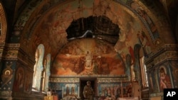 Ukrainian serviceman Gennadiy Yudin stands inside orthodox church damaged by a Russian bombing in Novoekonomichne, Ukraine, Sept. 17, 2024. 