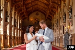 FILE - n this file photo taken on May 08, 2019 Britain's Prince Harry, Duke of Sussex (R), and his wife Meghan, Duchess of Sussex, pose for a photo with their newborn baby son, Archie Harrison Mountbatten-Windsor