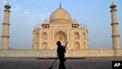 FILE - In this June 3, 2013, photo, a worker sweeps in front of Taj Mahal in Agra, India. India’s world-famous Taj Mahal is facing a new threat: insect poop.