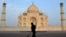 FILE - In this June 3, 2013, photo, a worker sweeps in front of Taj Mahal in Agra, India. Swarms of insects are proliferating in the heavily contaminated waters of the Yamuna River, which flows behind the 17th century monument.