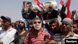 A supporter of deposed Egyptian President Mohamed Morsi wears a mask depicting Mursi as protesters chant slogans outside the Republican Guard headquarters in Cairo, July 7, 2013.