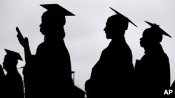 FILE - New graduates line up before the start of the Bergen Community College commencement at MetLife Stadium in East Rutherford, N.J., May 17, 2018.